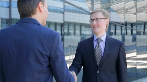 Two businessmen meet and shake hands Stock Footage