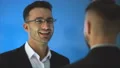 The two businessmen pat shoulder on the blue background. slow motion 4k or 4k+ Resolution