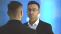 The two businessmen pat shoulder on the blue background. slow motion 4k or 4k+ Resolution