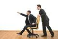 The two businessmen ride on the chair on the white wall background Photo