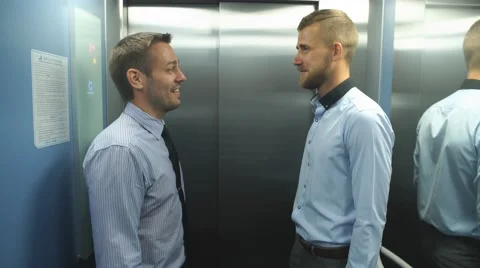 Two businessmen riding the Elevator and talking to Stock Footage 67497142