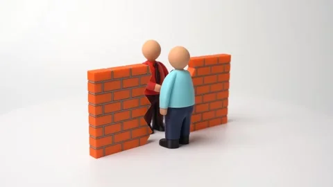 Two businessmen shake hands through a gap in a brick wall. Stock Footage 321355506