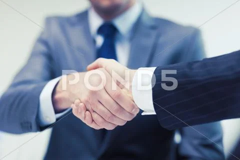 Two businessmen shaking hands in office Stock Photos