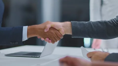 Two businessmen shaking hands over table with laptop in modern office durin.. Stock Footage 337445830
