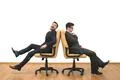 The two businessmen sit on chairs on the white wall background Photo