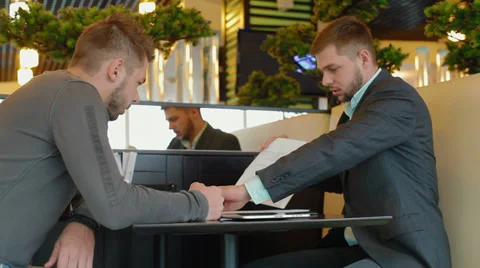 Two businessmen sitting at a table, they have a business meeting Stock Footage 30354231