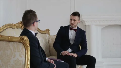 Two businessmen in suits with bow ties are communicating in a beautiful room Stock Footage 61518466