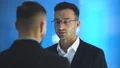 The two businessmen talk on the blue background. slow motion 4k or 4k+ Resolution