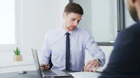 Two businessmen talk to each other, one of them reads a document Stock Footage 68401816