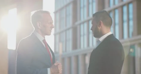Two businessmen talking and shaking hands outside office Stock Footage 156447553