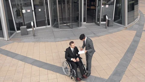 Two Businessmen talking outdoors close to Corporate Building. Colleague is on Stock Footage 110259690