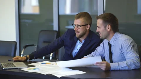 Two businessmen in talks considering the graphics Stock Footage 67499482
