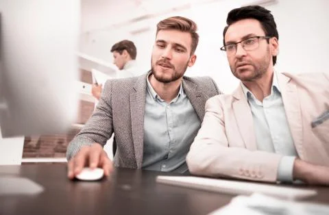 Two businessmen use a computer to get new information Stock Photos