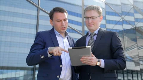 Two businessmen using digital tablet computer touchscreen Stock Footage 68055571