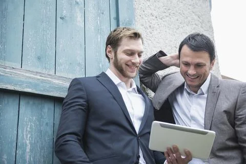 Two businessmen using digital tablet outside, Bavaria, Germany Stock Photos