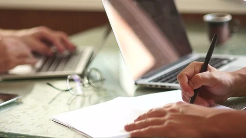 Two businessmen at work. Close-up hands and laptops. One man draws a scheme Stock Footage 96876205