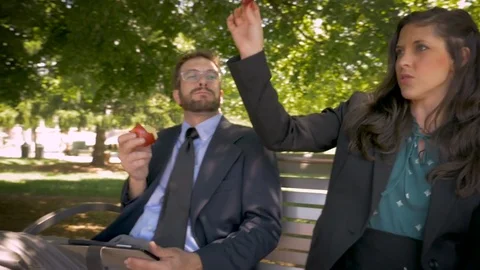 Two businesspeople dancing while sitting and eating healthy food for lunch Stock Footage 78230351