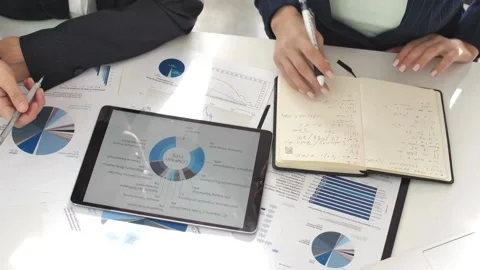Two businesspeople using digital tablet to analyzing data in an office Two Stock Footage 256742218