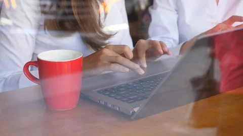 Two businesswomen working with notebook computer, hands closeup Stock Footage 95593228