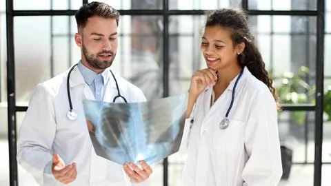 Two busy doctors working with papers and xray images Stock Photos