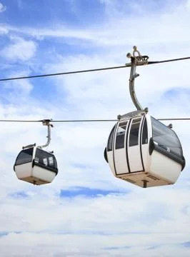 Two cable car on a partly cloudy sky background Stock Photos