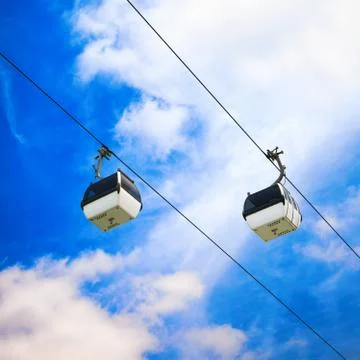 Two cable car on a partly cloudy sky background Stock Photos