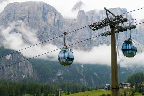 Two cable way cabins against the Dolomites covered with clouds Stock Photos