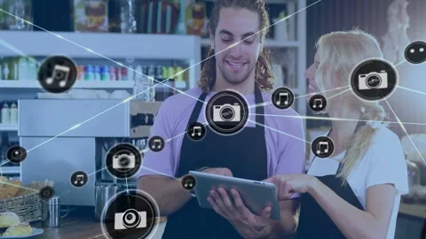 Two cafe staff collaborating with tablet, camera icon appearing and overlaying Stock Footage 332746943