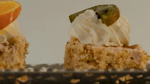 Two cake slices stand side by side on a white surface. The left piece features Video stock 309637934