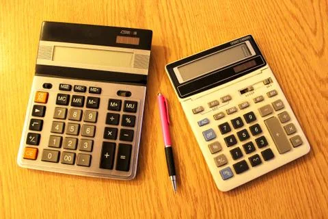 Two calculators on a table and the pen Stock Photos
