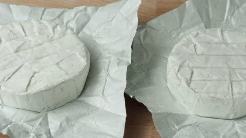 Two Camembert cheese head on white paper on cutting board. Stock Footage 201068792