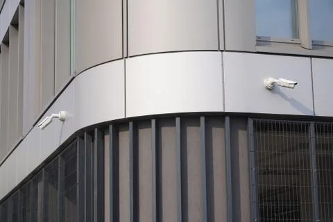 Two cameras CCTV on the facade of a modern office building on the street, sec Stock Photos