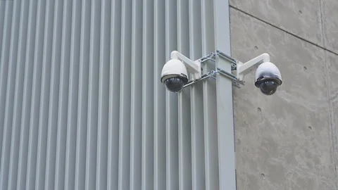 Two cameras fixed on a building in a white case dome metal concrete. background Vídeo Stock 115596519