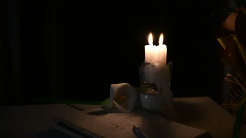 Two candle is burning on the table, someone is blowing out the burning candles Stock Footage 156758285