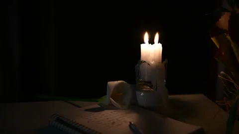 Two candle is burning on the table, someone is blowing out the burning candles Stock Footage 156759991