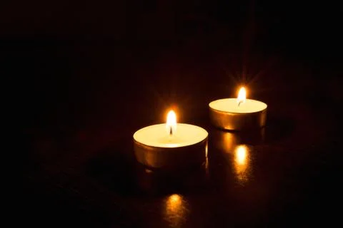 Two candles on a black background. Stock Photos