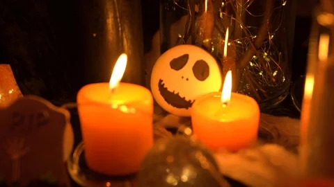 Two candles burn on the table and illuminate the skull-shaped liver Stock Footage 125841829