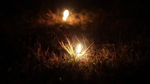 Two candles burning down in the grass Stock Footage 61771536