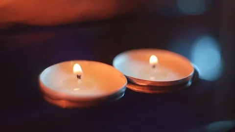 Two candles float in the water in the darkness, warm tones Stock Footage 114064181
