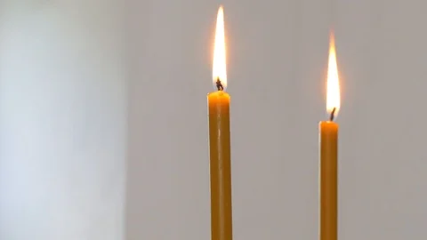 Two candles slowly flickers on a real wall background Stock Footage 97644730