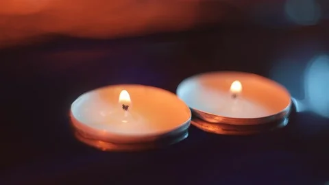 Two candles slowly float in the water in the darkness, warm tones Stock Footage 114064317
