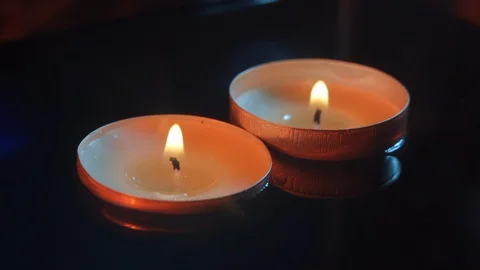 Two candles still floating in the water in the darkness, warm tones Stock Footage 114064034