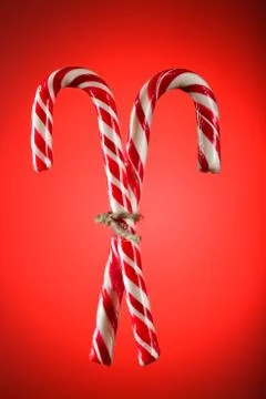 Two candy canes on a red background. Christmas, a holiday concept. Useful as Stock Photos