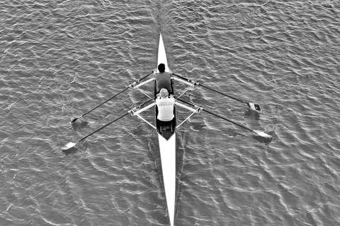 Two canoeists rowing on the Arno River in Florence, Italy on a clear day Stock Photos