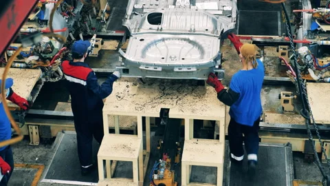 Two car factory workers moving a car body using chains 스톡 동영상 143244311