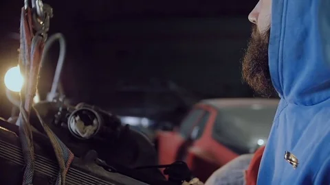 Two car mechanic with a mini crane pull out of the car motor. Stock Footage 77175786