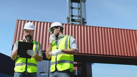 Two cargo container workers or engineer men work in front of big container Stock Footage 146475552
