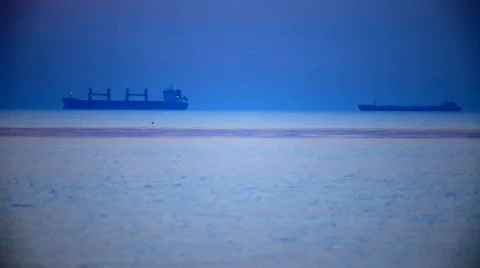 Two cargo ship in the distance at sunset Stock Footage 729802