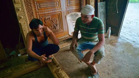 Two carpenter seated in wood workshop Stock Footage 301437469