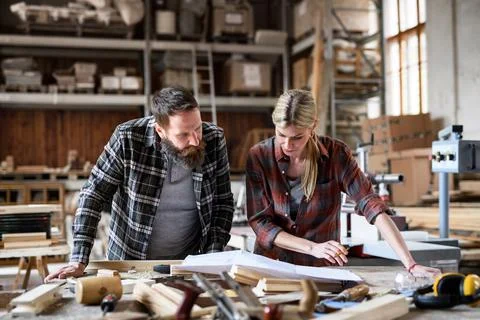 Two carpenters man and woman talking about design of products. Small business Stock Photos